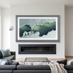 gray frame tv frame 65 inch on a modern white wall with black fireplace below, in the tv there is a white mat and modern birds view of a lake tv art, handmade tv bezel for Samsung The Frame 55