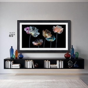the frame tv frames 65 inch black tv bezel Samsung the frame contemporary in a modern living room, black tv console with modern black and translucent flower tv art with white mat, decorative glass bottles and vases on the tv console