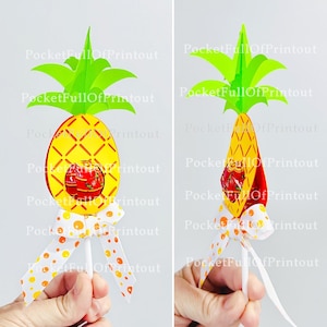 May include: A yellow pineapple-shaped lollipop holder with a green pineapple top. The holder has a red and white polka dot ribbon and a red sweet inside. The lollipop stick is white.