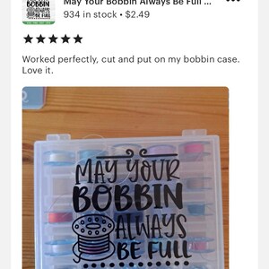 以下が含まれることがあります： 「May Your Bobbin Always Be Full」と書かれた黒いビニールステッカーが付いた白いプラスチック製のボビン収納ケースです。