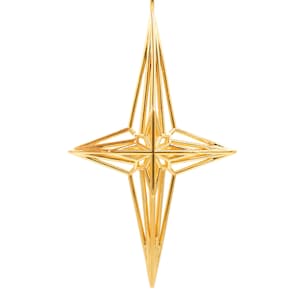 Può includere: Un ornamento natalizio a forma di stella geometrica dorata. La stella è realizzata con sottili fili metallici intrecciati per creare un design tridimensionale.