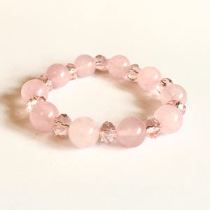 May include: A pink bracelet with round pink beads and clear crystal beads.