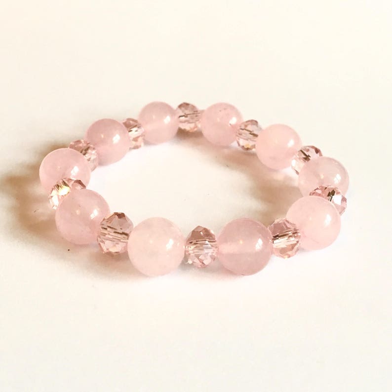 May include: A pink bracelet with round pink beads and clear crystal beads.