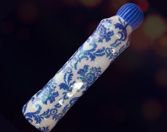 May include: A white marker with a blue floral pattern and a blue cap. The marker has a glittery finish.