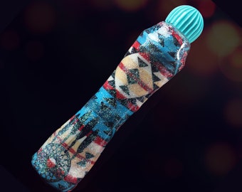 May include: A turquoise and blue glitter marker with a geometric pattern. The marker has a turquoise cap with a ridged top.