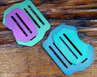 May include: Two metal wallet inserts, one purple and one blue, with a textured, iridescent finish. The inserts have multiple slots for holding cards.