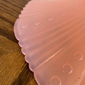Peut inclure: Un abat-jour de lampe en verre rose p&acirc;le avec un bord festonn&eacute; et une surface textur&eacute;e. L'abat-jour a une s&eacute;rie de petites indentations rondes.