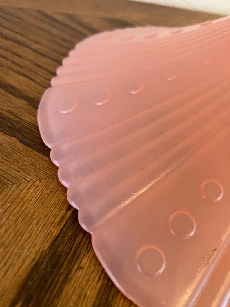 Peut inclure: Un abat-jour de lampe en verre rose p&acirc;le avec un bord festonn&eacute; et une surface textur&eacute;e. L'abat-jour a une s&eacute;rie de petites indentations rondes.