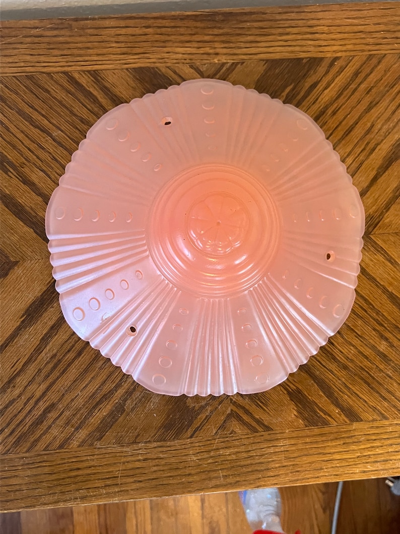 Peut inclure: Un luminaire de plafond en verre rose avec un bord festonn&eacute; et un motif floral au centre.