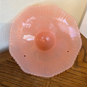 Peut inclure: Un luminaire de plafond en verre rose p&acirc;le avec un bord festonn&eacute; et un motif &agrave; pois. Le luminaire a trois trous pour le montage.