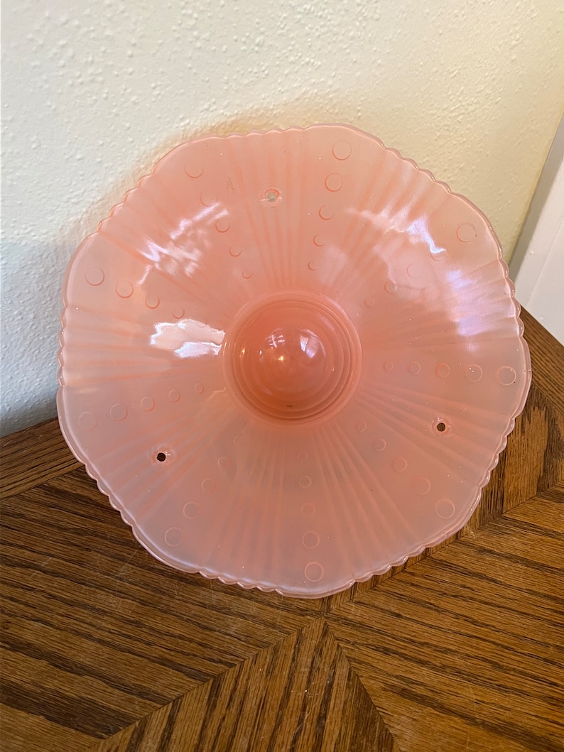Peut inclure: Un luminaire de plafond en verre rose p&acirc;le avec un bord festonn&eacute; et un motif &agrave; pois. Le luminaire a trois trous pour le montage.