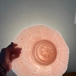 Peut inclure: Un luminaire de plafond en verre rose avec un bord festonn&eacute; et un motif floral au centre.