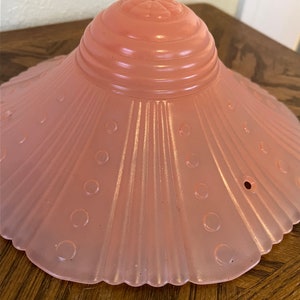 Peut inclure: Un abat-jour de lampe en verre rose p&acirc;le avec un bord festonn&eacute; et un motif textur&eacute; et c&ocirc;tel&eacute;. L'abat-jour a un petit motif floral en relief sur le dessus.