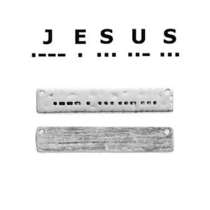 Könnte beinhalten: Zwei rechteckige silberne Metalletiketten mit dem Wort "JESUS" und dem Wort in Morsecode geschrieben. Das obere Etikett hat eine gehämmerte Textur und das untere Etikett eine gebürstete Textur.