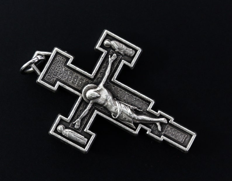 Op de afbeelding: Zilveren kruis hanger met een gedetailleerd ontwerp met een figuur van Jezus Christus aan het kruis. Het kruis heeft een decoratieve rand en de inscriptie "INRI" is zichtbaar.