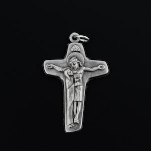 May include: A silver pendant in the shape of a cross with a depiction of Jesus Christ and Mary. The cross is detailed with a crown of thorns and a halo.