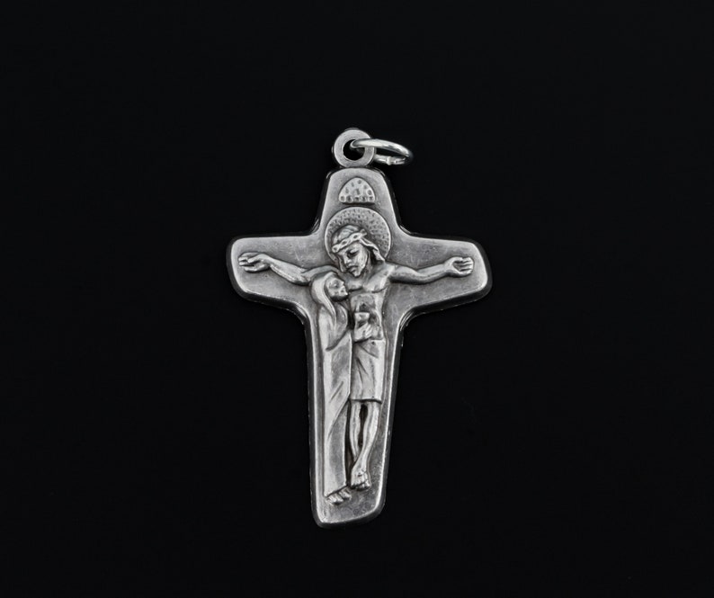 May include: A silver pendant in the shape of a cross with a depiction of Jesus Christ and Mary. The cross is detailed with a crown of thorns and a halo.