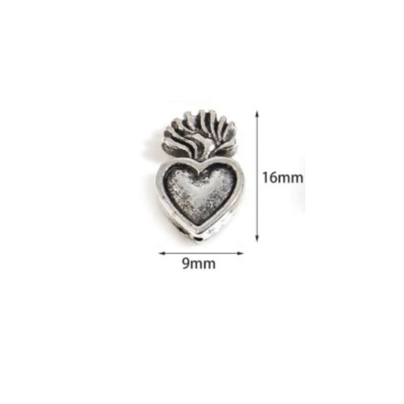 May include: Silver charm in the shape of a heart with a flame design on top. The charm is 9mm wide and 16mm tall.