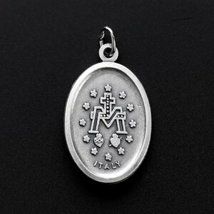 May include: Silver pendant with a detailed image of the Virgin Mary and the words "ITALY" on the bottom.