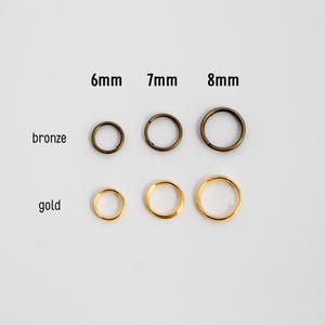 May include: Close-up of bronze and gold jump rings in 6mm, 7mm, and 8mm sizes. The jump rings are arranged in rows, with the bronze rings above the gold rings. The text labels the sizes.