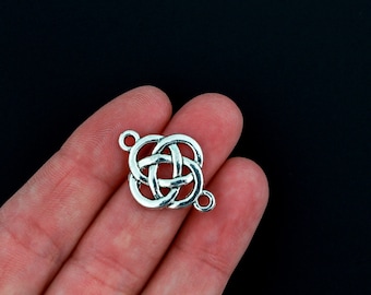 May include: Silver Celtic knot charm with two jump rings. The knot is a traditional design with intricate details.