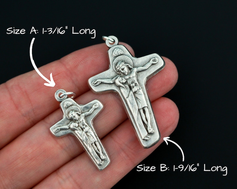 May include: Two silver crucifix pendants, one measuring 1-3/16 inches long and the other measuring 1-9/16 inches long.