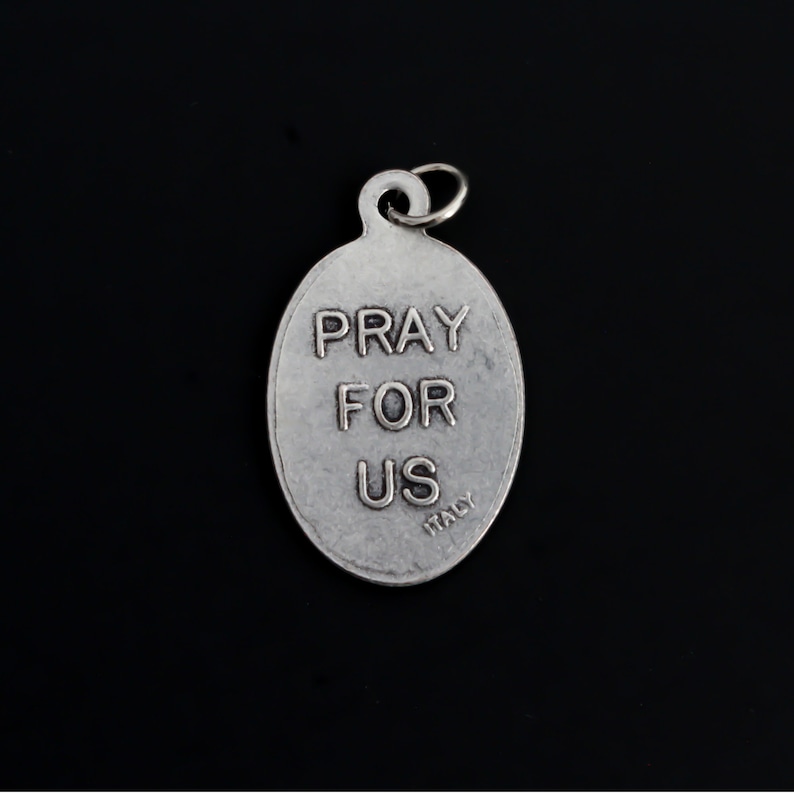 May include: Silver oval charm with the words "Pray for Us" and "Italy" inscribed on it.