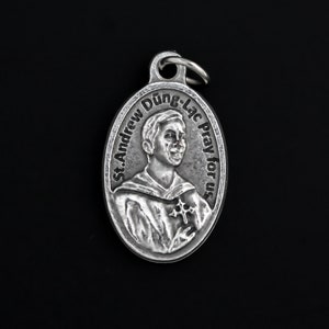 Peut inclure: Pendentif ovale en argent représentant Saint André Dung-Lac. Le pendentif porte l'inscription "St. Andrew Dung-Lac Pray for us".