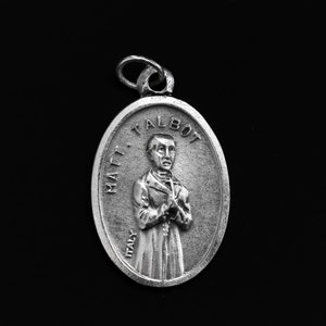 Könnte beinhalten: Silberner ovaler Anhänger mit einem Reliefbild eines Mannes mit dem Text "MATT. TALBOT ITALY" am Rand.