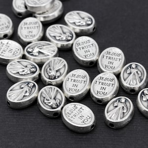 Puede incluir: Una colecci&oacute;n de cuentas ovaladas de plata con las palabras "Jes&uacute;s conf&iacute;o en ti" grabadas en cada cuenta. Las cuentas tienen una imagen en relieve de Jes&uacute;s en el centro.