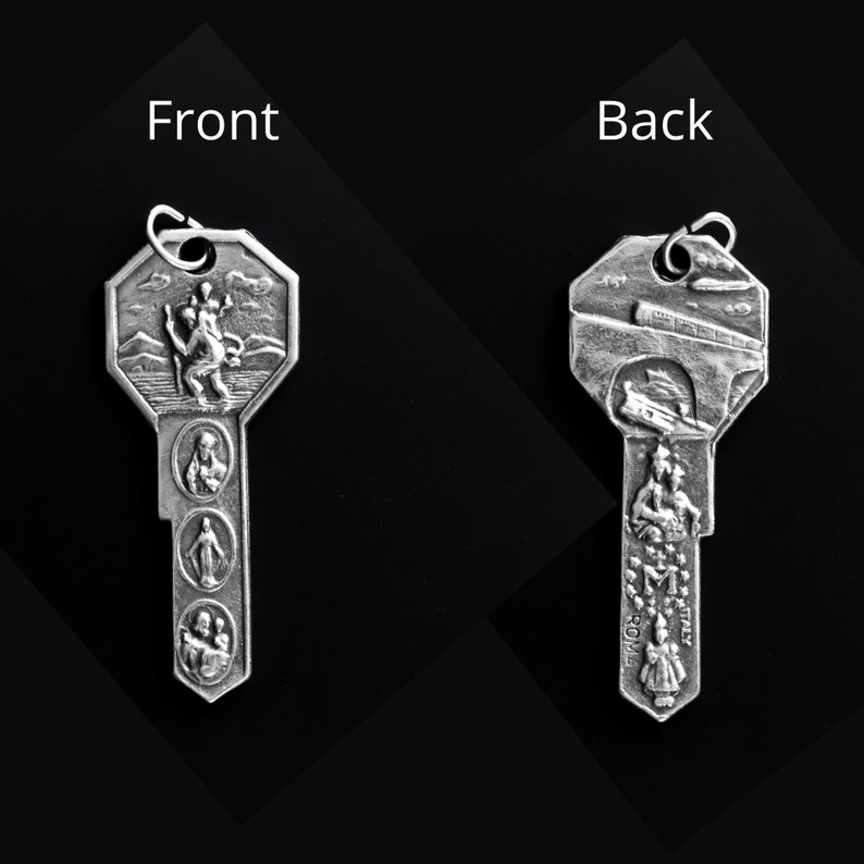 May include: Silver key-shaped pendant with a religious design. The front features a depiction of Saint Christopher carrying a child. The back features a depiction of a bridge and the words "Roma" and "Italy".