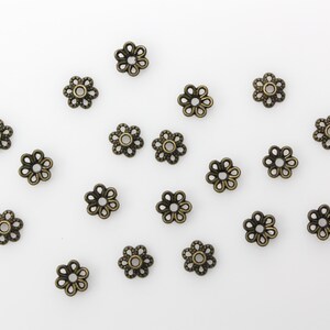 Puede incluir: Una colecci&oacute;n de 18 tapas de cuentas de metal de color dorado antiguo en forma de flor. Las tapas de cuentas tienen un dise&ntilde;o delicado e intrincado.