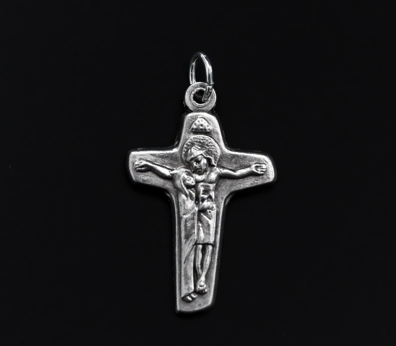May include: A silver crucifix pendant with a detailed image of Jesus Christ on the cross.