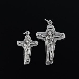 May include: Two silver crucifixes with a depiction of Jesus Christ and Mary. The larger crucifix is about 5 inches tall and the smaller crucifix is about 3 inches tall.