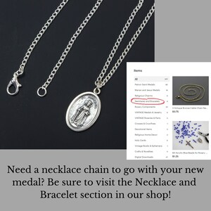 May include: Silver chain necklace with a silver oval pendant featuring a religious image of a woman. The pendant is attached to a silver chain with a lobster clasp. The image is of a woman in a long robe with her hands clasped in prayer. The image is surrounded by a border with the words "St. Dymphna" inscribed on it. The necklace is displayed on a white background with a list of items for sale, including necklaces and bracelets.