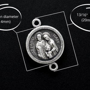 May include: A silver-colored Holy Family pendant, 9/16 inch in diameter and 13/16 inch long, with the words "HOLY FAMILY ITALY" inscribed. The pendant features a detailed relief of a family. The pendant has two loops for attachment.