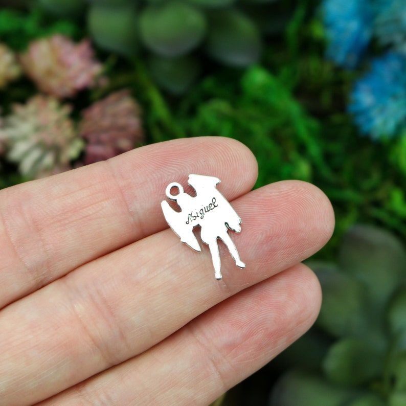 May include: Silver angel charm with the name "Miguel" inscribed on the back.
