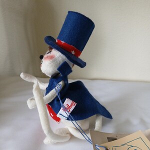 Peut inclure: Une peluche patriotique sur le th&egrave;me de l'Oncle Sam. Le jouet est blanc avec un haut-de-forme bleu orn&eacute; d'une bande rouge et blanche &agrave; motifs d'&eacute;toiles. Il porte une cape bleue avec une cravate rouge et blanche &agrave; motifs d'&eacute;toiles. Une &eacute;tiquette est attach&eacute;e.