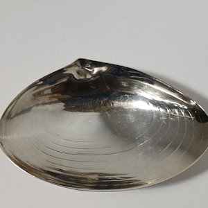 Puede incluir: Un juego de tres tazas de cerámica con un esmalte moteado de color crema. Cada taza presenta un diseño pintado a mano diferente: una hoja azul y verde, una flor amarilla y una baya roja. Las tazas tienen un diseño simple y moderno.