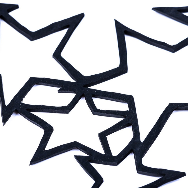 May include: Three black paper stars with intricate cutouts, arranged in a layered pattern against a white background.