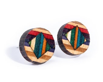 Könnte beinhalten: Ein Paar runde Holzohrringe mit einem farbenfrohen geometrischen Design. Die Ohrringe sind aus Holz und haben eine natürliche Oberfläche. Das Design zeigt eine Diamantform mit Streifen in Rot, Orange, Gelb, Grün, Blau, Lila und Schwarz.