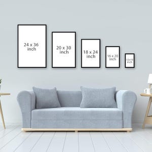 以下が含まれることがあります： さまざまなサイズの5つの額入りアートプリントが、30x46cmから61x91cmまで、水色のソファの上に展示されています。各フレームは黒い縁と白い内側を持っています。サイズは各フレームに表示されています。