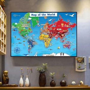 Peut inclure: Une carte du monde colorée, encadrée et affichant le titre "Map of the World". Les continents sont colorés et illustrés avec des animaux et des monuments. La carte est accrochée au mur.
