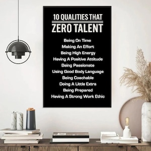 May include: A black poster with white text listing "10 QUALITIES THAT ZERO TALENT" including "Being On Time", "Making An Effort", and "Having A Strong Work Ethic". The poster is displayed on a wooden surface.