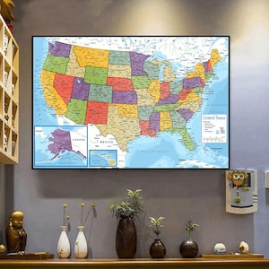 Pode incluir: Um mapa emoldurado dos Estados Unidos, mostrando cada estado em uma cor diferente. Inclui mapas do Alasca, Havaí e áreas circundantes. O mapa está pendurado em uma parede acima de uma prateleira de madeira com vasos decorativos.