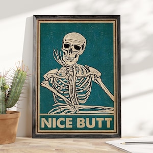May include: A vintage-style poster featuring a skeleton with a skull and crossbones sitting with its arms crossed. The poster has a teal background and the text "NICE BUTT" in yellow letters.