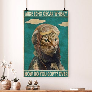 May include: Vintage style poster featuring a cat wearing a pilot's helmet and goggles. The text reads "Mike Echo Oscar Whisky How Do You Copy? Over".