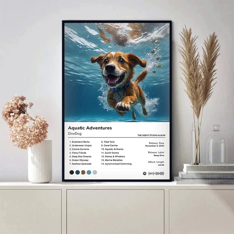May include: A framed poster featuring a happy brown and white dog swimming underwater. The poster is titled "Aquatic Adventures" by DiveDog, with a tracklist and album details. The background is a vibrant blue, with a few small fish.