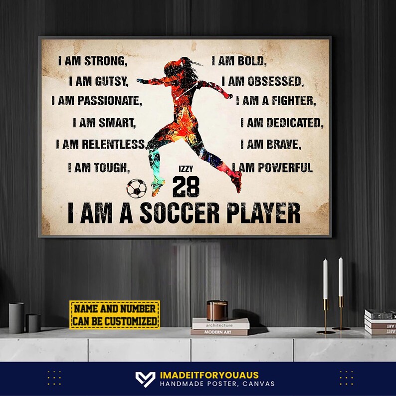 Peut inclure: Une affiche encadr&eacute;e avec une silhouette de joueur de football aux couleurs vives. Le texte comprend "I AM STRONG" et "I AM A SOCCER PLAYER." Le nom et le num&eacute;ro du joueur, "IZZY 28", sont affich&eacute;s. Une option de nom et de num&eacute;ro personnalisable est &eacute;galement pr&eacute;sente.
