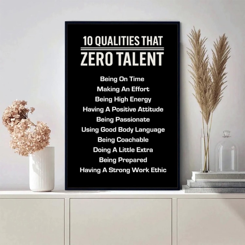 May include: A framed black and white print with the text "10 QUALITIES THAT ZERO TALENT" and a list of ten qualities. The print is displayed on a white cabinet with decorative plants.